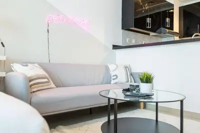 a living room with a couch and a table at SUNRISE HOMES - A Modern Studio near JBR Beach in Dubai
