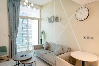 a living room with a couch and a clock on the wall at Beautiful 1 bed apartment Marina I Sleeps 4 in Dubai