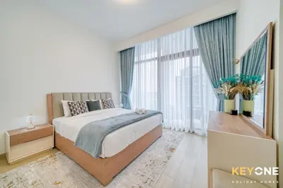 a bedroom with a bed and a large window at Exquisite Living in Riviera One Bedroom in Dubai