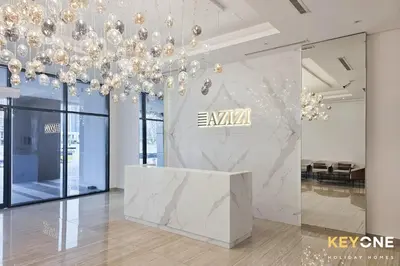 a lobby with aidium sign on the wall and a large chandelier at Exquisite Living in Riviera One Bedroom in Dubai