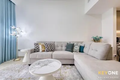 a living room with a couch and a table at Exquisite Living in Riviera One Bedroom in Dubai