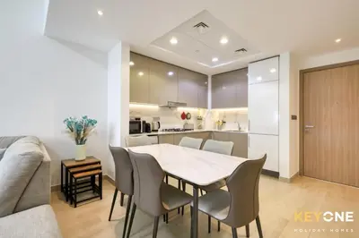a kitchen and dining room with a table and chairs at Exquisite Living in Riviera One Bedroom in Dubai