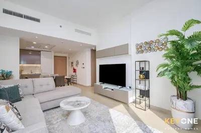 a living room with a couch and a tv at Exquisite Living in Riviera One Bedroom in Dubai
