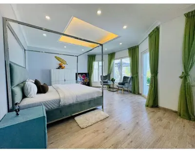 a bedroom with a large bed with a ceiling at Palm villas in Dubai