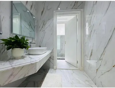 a white bathroom with a sink and a mirror at Palm villas in Dubai