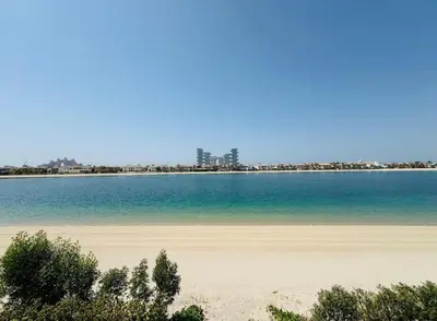 a beach with the ocean and buildings in the background at Palm villas in Dubai