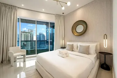 a bedroom with a large white bed and a large window at Lux 5BR Marina Apt with Jacuzzi, Walk to Beach, Gym in Dubai