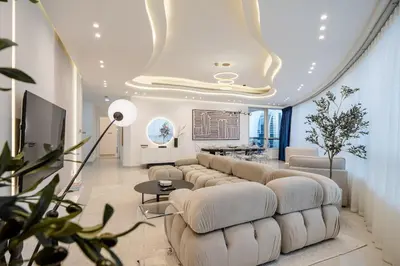 a living room with a large couch and a table at Lux 5BR Marina Apt with Jacuzzi, Walk to Beach, Gym in Dubai