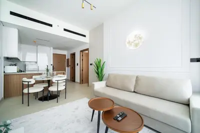 a living room with a couch and a table at SettlerHomes - Serene JVC 1BR With Modern Luxury in Dubai