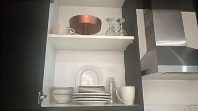a kitchen cupboard with plates and dishes on it at Capital bay in Dubai