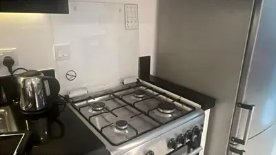 a stove top oven in a kitchen next to a refrigerator at Capital bay in Dubai
