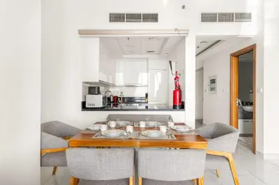 a dining room with a wooden table and chairs at 2BR Canal View Flat with Pool, Gym, 10 min Drive to Dubai Mall in Dubai