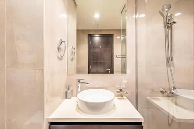 a white bathroom with a sink and a shower at Stylish 1BR Business Bay - Near Metro - Balcony with City Views in Dubai