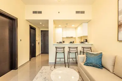 a living room with a couch and a kitchen at Stylish 1BR Business Bay - Near Metro - Balcony with City Views in Dubai
