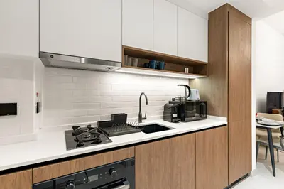 a kitchen with a sink and a stove top oven at Chic Dubai Studio with Balcony, Pool, Gym, Free Parking Near Expo Metro in Dubai