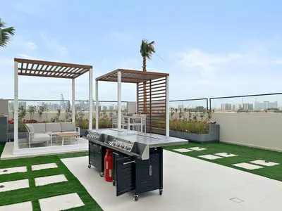 a patio with a grill on top of a building at Chic Dubai Studio with Balcony, Pool, Gym, Free Parking Near Expo Metro in Dubai