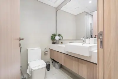 a bathroom with a sink and a toilet and a mirror at Dubai Studio - Trendy Interiors - City Views in Dubai