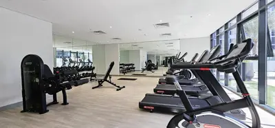 a gym with a bunch of treadmills and machines at Dubai Studio - Trendy Interiors - City Views in Dubai