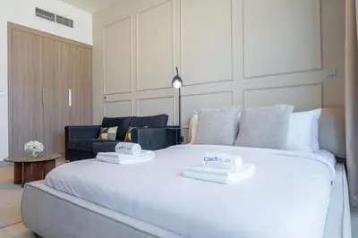 a bedroom with a large white bed with two towels on it at Dubai Studio - Trendy Interiors - City Views in Dubai