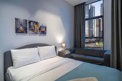a bedroom with a bed and a couch and a window at Lavish Studio at 15 Northside W City Skyline View 3rd floor in Dubai