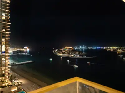 a view of a harbor at night with boats in the water at Ultra-Luxury 2 Bedroom Beachfront Escape with Sea Views in Dubai