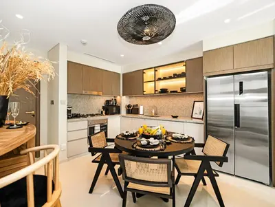 a kitchen with a table and chairs and a refrigerator at Ultra-Luxury 2 Bedroom Beachfront Escape with Sea Views in Dubai