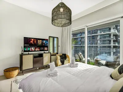 a bedroom with a large white bed and a tv at Ultra-Luxury 2 Bedroom Beachfront Escape with Sea Views in Dubai