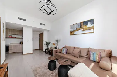 a living room with a couch and a kitchen at Convenient 1BR apartment in Business Bay in Dubai