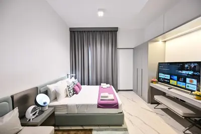 a bedroom with a bed and a flat screen tv at Charming Studio in Meydan by Deleguest in Dubai
