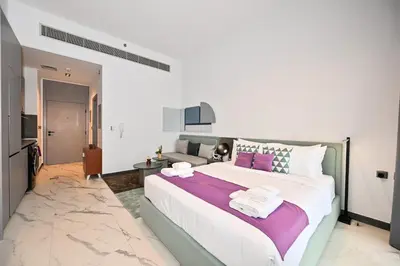 a bedroom with a large bed and a couch at Charming Studio in Meydan by Deleguest in Dubai