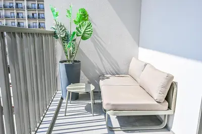 a living room with a couch and a plant on a balcony at Charming Studio in Meydan by Deleguest in Dubai