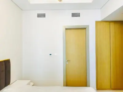 a room with two beds and a wooden door at ايكون ستي 2BEd in Dubai