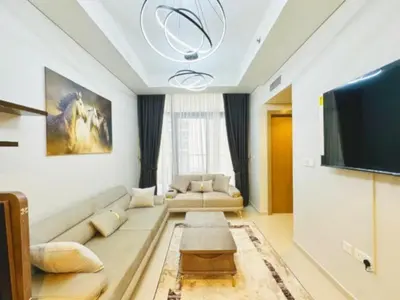 a living room with a couch and a flat screen tv at ايكون ستي 2BEd in Dubai
