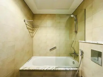 a bathroom with a bath tub with a shower at ايكون ستي 2BEd in Dubai