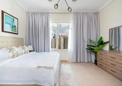 a bedroom with a white bed and a window at Bespoke Holiday Homes - 2BR Apartment with Riva Beach Club Access, Al Nabat in Dubai