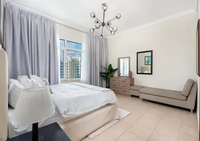 a white bedroom with a bed and a window at Bespoke Holiday Homes - 2BR Apartment with Riva Beach Club Access, Al Nabat in Dubai