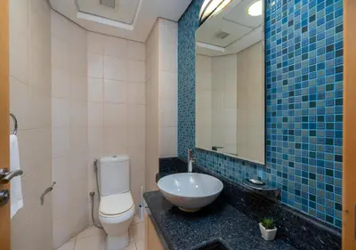 a bathroom with a sink and a toilet and a mirror at Bespoke Holiday Homes - 2BR Apartment with Riva Beach Club Access, Al Nabat in Dubai