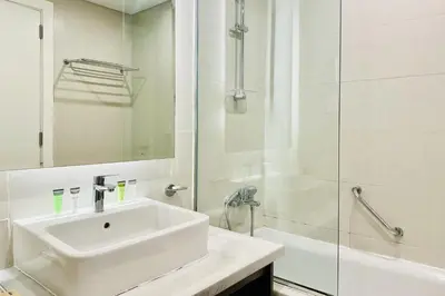 a white bathroom with a sink and a shower at Vserve - Stylish specious - 1 Bedroom with Canal View in Dubai