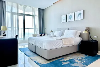 a bedroom with a large white bed with a blue rug at Vserve - Stylish specious - 1 Bedroom with Canal View in Dubai