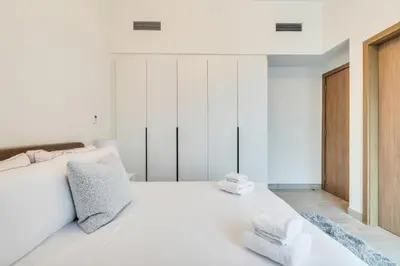a bedroom with a white bed with two towels on it at Dubai Luxury 4BR Villa in Murooj Al Furjan in Dubai