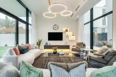 a living room with white walls and large windows at Dubai Luxury 4BR Villa in Murooj Al Furjan in Dubai