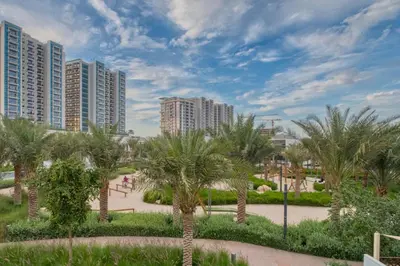 a park with palm trees and tall buildings at Dubai Luxury 4BR Villa in Murooj Al Furjan in Dubai