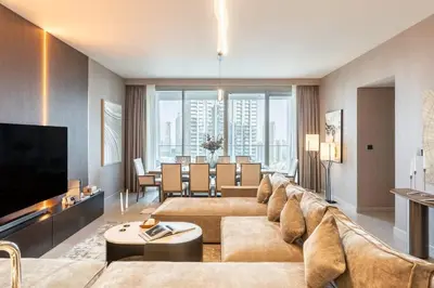 a living room with a large couch and a dining room at Royal 4BR Burj Khalifa View Dubai Mall in Dubai