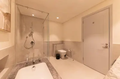 a bathroom with a shower and a tub and a toilet at Royal 4BR Burj Khalifa View Dubai Mall in Dubai