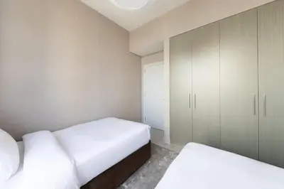 a bedroom with two beds and a cabinet at Royal 4BR Burj Khalifa View Dubai Mall in Dubai