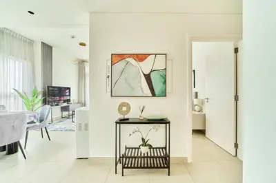a living room with a table with flowers on it at Stylish 2BR Apartment Steps from Dubai Hills Mall in Dubai