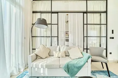 a living room with a white couch and a chair at Stylish 2BR Apartment Steps from Dubai Hills Mall in Dubai