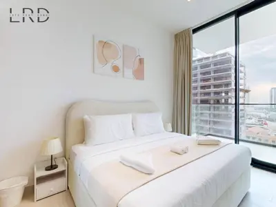a bedroom with a large white bed with a large window at Brand New and Modern Smart Home 1BR in Dubai