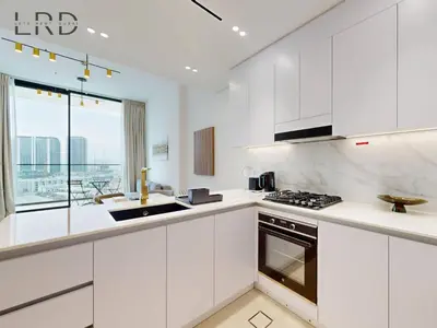 a white kitchen with white cabinets and a window at Brand New and Modern Smart Home 1BR in Dubai