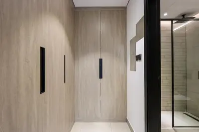 a hallway with a wooden door and a shower at Livbnb-Stylish and Spacious 1BR Apartment with Private Balcony in Dubai